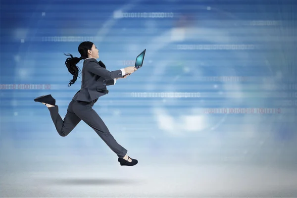 Female worker with laptop runs in cyberspace — Stock Photo, Image