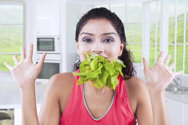 Zdravá žena jíst špenát doma — Stock fotografie