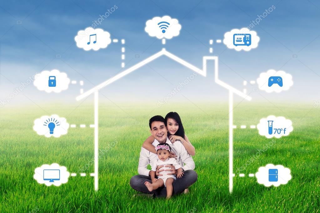 Family sits at field under smart house design