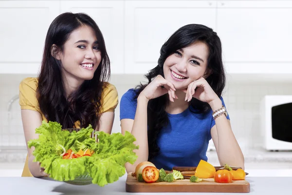 Duas mulheres mostrando salada de legumes — Fotografia de Stock