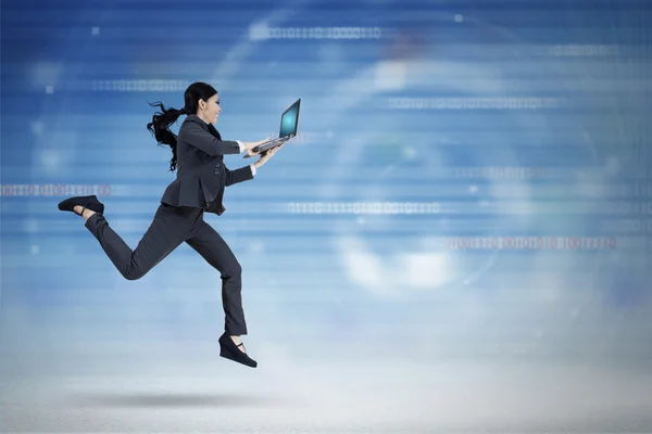 Businesswoman with laptop runs in virtual world — Stock Photo, Image