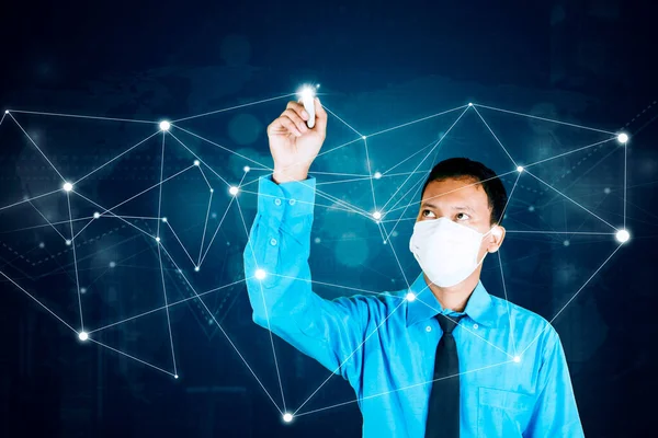 年轻的商人戴着医疗面具 在虚拟屏幕上绘制网络连接线 — 图库照片