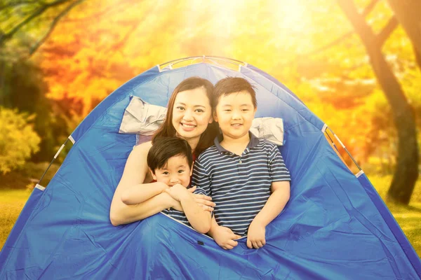 秋天的时候 快乐的母亲抱着儿子在帐篷里露营的情景 — 图库照片