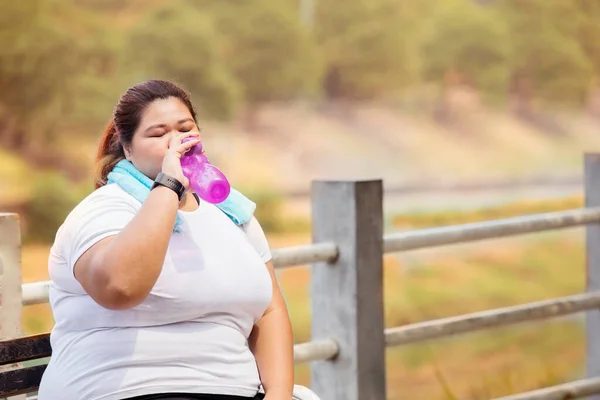 Overweight Woman Drinking Bottle Water Doing Run Exercises While Sitting — Stock Photo, Image