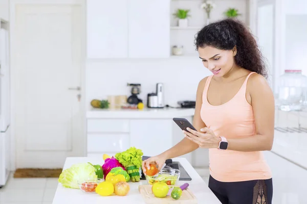 Ung Kvinna Som Använder Smartphone Och Förbereda Hälsosam Sallad Köket — Stockfoto