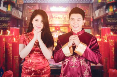 Çinli genç bir çiftin, tapınakta yeni yılı kutlarken kameraya gülümsemesi.