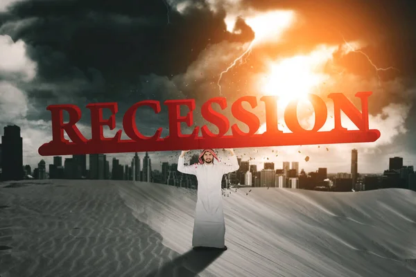 Арабский Бизнесмен Держит Слово Рецессии Стоя Пустыне Облачном Фоне Неба — стоковое фото