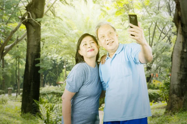 Starsza Para Robi Sobie Selfie Ćwiczeniach Stojąc Razem Parku — Zdjęcie stockowe