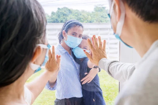 一对悲伤的老夫妇与他们的孩子和孙女见面 同时在感染Covid 19之后进行自我隔离 并在家里透过窗户交谈 — 图库照片