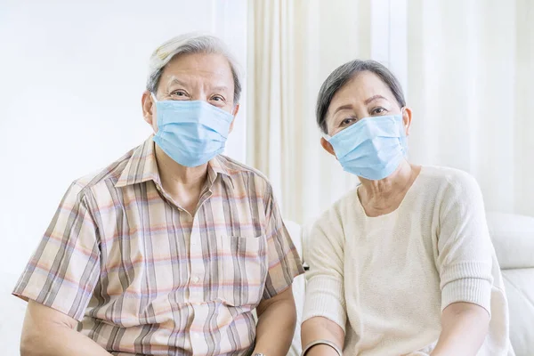 코로나 바이러스 예방을 의료용 마스크를 소파에 부부가 폐장되었다 가정에서 — 스톡 사진