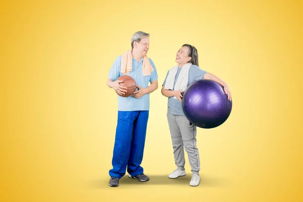 Senior Par Bär Sportkläder Medan Håller Pilates Boll Och Basket — Stockfoto