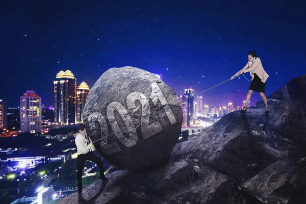 Business Couple Climbing Hill While Pulling Pushing Rock 2021 Numbers — ストック写真