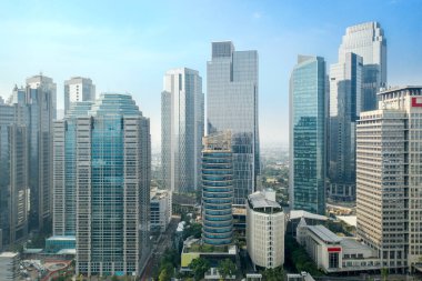 JAKARTA - Endonezya. 02 Aralık 2020: Jakarta şehrinde mavi gökyüzü arka planına sahip modern yüksek binaların insansız hava aracı görüntüsü