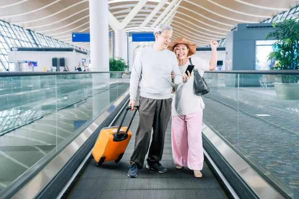 Senior Couple Carrying Luggage While Using Smartphone Happy Expression Escalator — Stok fotoğraf