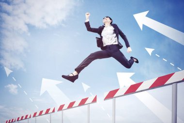 Genç iş kadınının mavi gökyüzü arka planına sahip yukarı doğru ok atlarken alçak açılı görüntüsü