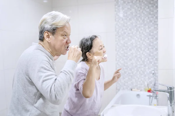 Banyoda Dans Ederken Dişlerini Fırçalayan Yaşlı Çiftin Yan Görüntüsü Evde — Stok fotoğraf