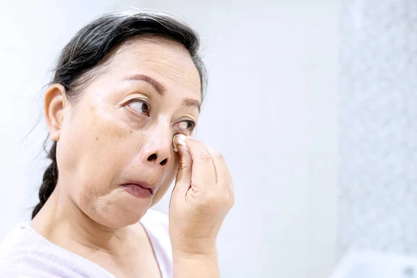 Zbliżenie Starszą Kobietę Czyszczącą Twarz Podkładkami Bawełnianymi Podczas Leczenia Skóry — Zdjęcie stockowe