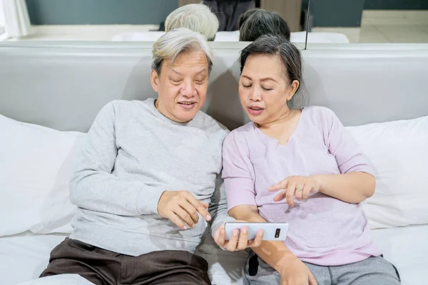 노부부가 침대에 핸드폰을 사용하여 비디오 통화를 있습니다 가정에서 — 스톡 사진