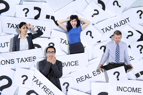 Stressed business people standing with tax problem and question mark symbol