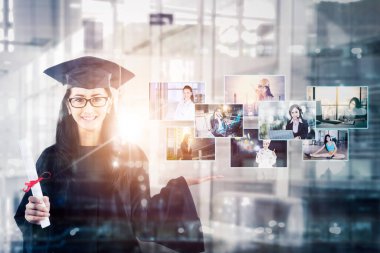 Yüksek lisans öğrencisinin çift pozu işlerinin resimlerini gösterirken mutlu görünüyor ve gökdelenlerin arka planında duruyor.