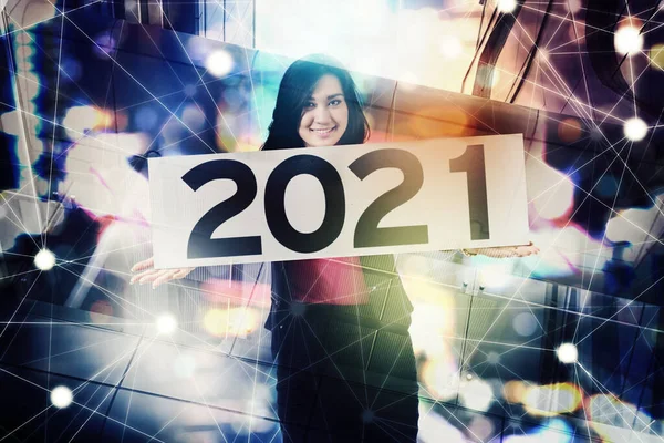 Szczęśliwa Businesswoman Trzyma Tablicę Numerem 2021 Stojąco Rozmazanym Błyszczącym Tle — Zdjęcie stockowe