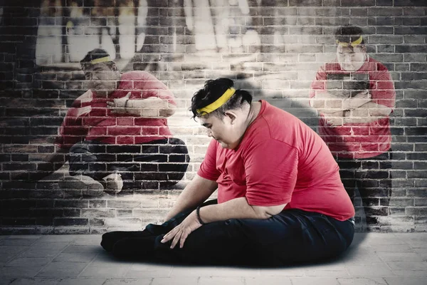 Obez Adamın Spor Giyim Kuşamaları Giyerken Duvar Arkası Tuğlalarla Otururken — Stok fotoğraf
