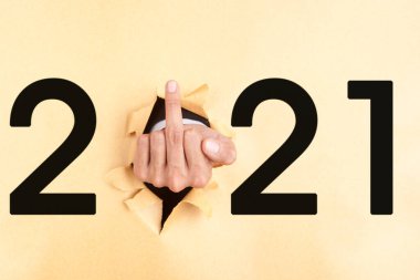 Yırtılan kağıdın orta parmağını gösteren iş adamı eliyle 2021 'e yakın rakam. Mutlu yıllar konsepti
