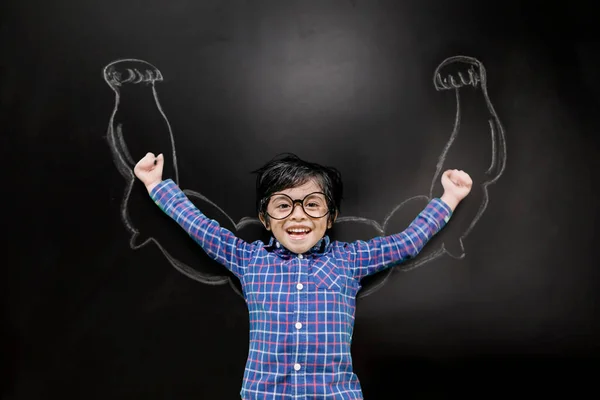 Фото Счастливого Маленького Мальчика Поднимающего Руки Стоя Нарисованными Бицепсами Доске — стоковое фото