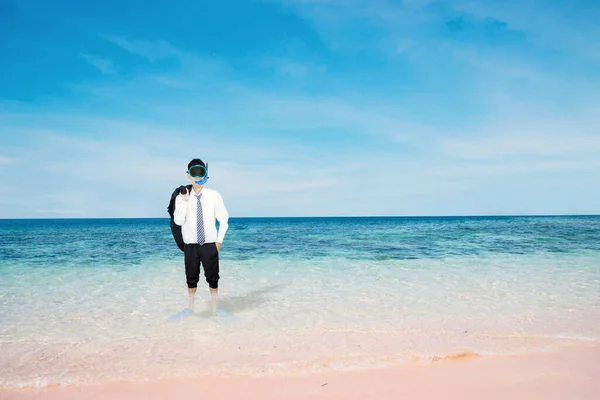 熱帯のビーチに立っている間にシュノーケリング用具を身に着けている若いビジネスマン — ストック写真