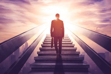 Arka planda, modern şehir arka planında merdivenlerde yürürken bir valiz taşıyan erkek yöneticinin görüntüsü var.