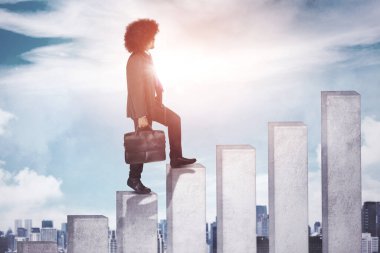 Kentin arka planında, büyüme finansal tablosunda yürürken bavul taşıyan genç işadamının yan görüntüsü