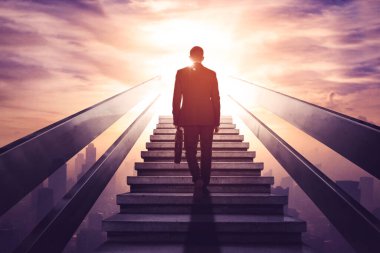 Arka planda, modern şehir arka planına sahip merdivenlerde yürürken erkek yöneticinin bavul taşıdığı görülüyor.