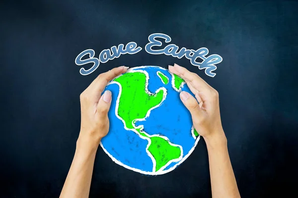 Close up of unknown hands holding an earth planet with Save Earth text on blackboard background