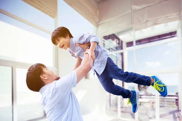 Close up of happy father lifting his son while playing together in the living room. Shot at home