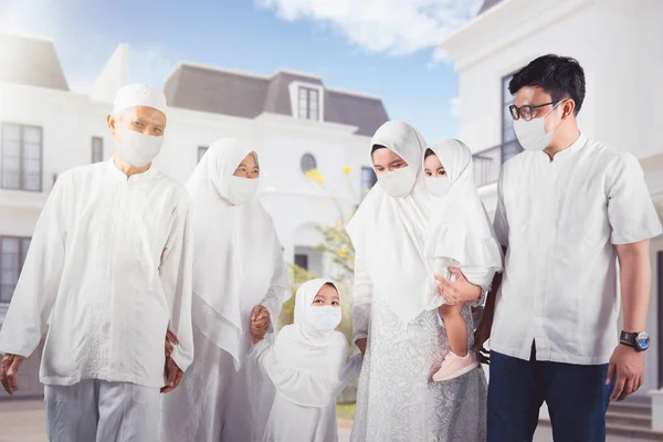 在开斋节期间 三代穆斯林家庭带着面具站在屋前 在室外开枪 — 图库照片