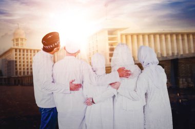 Mübarek Bayramı 'nda cami binasına bakarken yüz maskesi takan üç nesil Müslüman ailenin geçmişe bakış. Açık havada vuruldu.