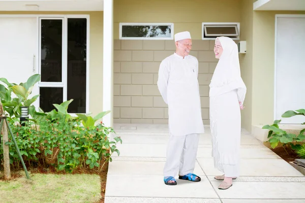 Eid Mubarak中に彼らの家の前に立っている間 幸せなイスラム教徒の高齢者のカップルは一緒にチャット — ストック写真