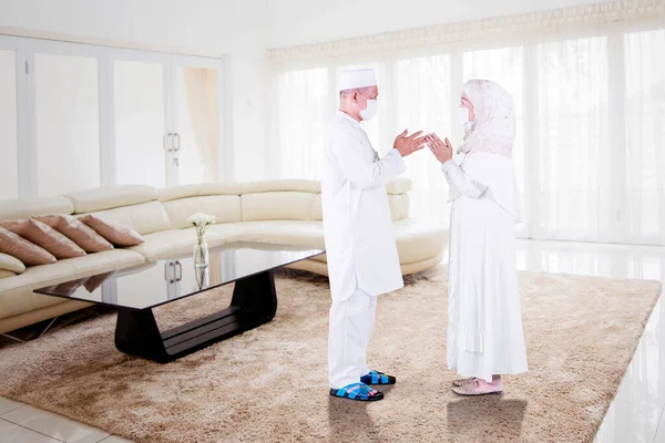 在开斋节期间 这对穆斯林老夫妇在家里的客厅里手牵手 互相道歉 — 图库照片