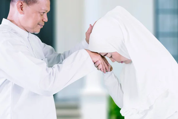 在穆巴拉克节日期间 穆斯林老妇人在屋前亲吻丈夫的双手并相互原谅 — 图库照片