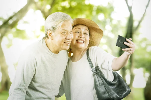 Elderly Couple Taking Selfie Photo Together While Doing Vacation Park — Stock Photo, Image