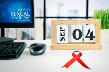 Eylül ayının takvimine yakın bir zamanda Dünya Cinsel Sağlık Günü metnini gösteren bilgisayar masaüstünü kapat ve 04 tarihini pencerenin yanındaki ofis masasında göster