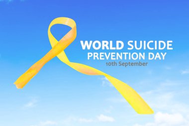 Close up of yellow ribbon with World Suicide Prevention Day text in the blue sky background