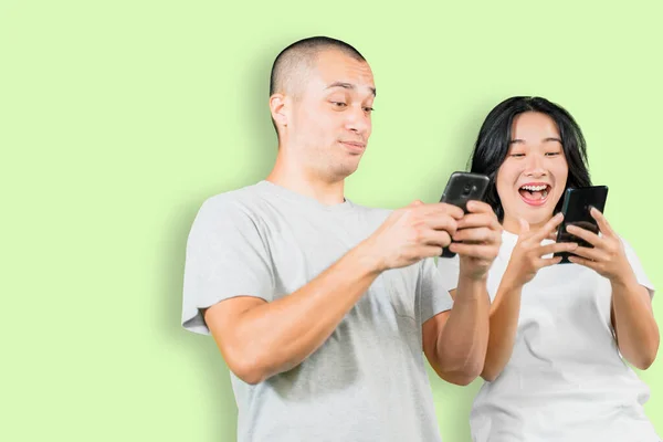Picture Happy Young Couple Standing Studio While Using Mobile Phone — Stock fotografie