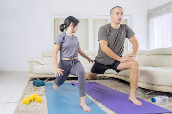 Young Couple Wearing Sportswear While Stretching Legs Together Exercising Living — Stockfoto