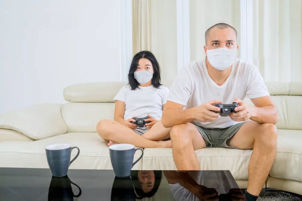 Young Couple Playing Video Games Together Home While Wearing Face — Stok fotoğraf