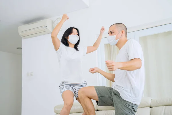 Happy Young Couple Doing Silly Dance Couch While Wearing Face — Φωτογραφία Αρχείου