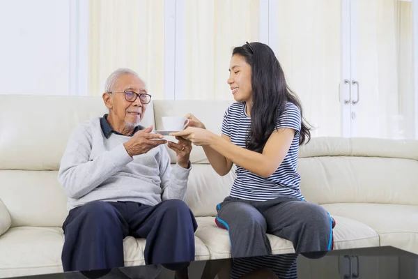 Portrait Happy Young Woman Giving Hot Tea Her Old Father — Foto Stock