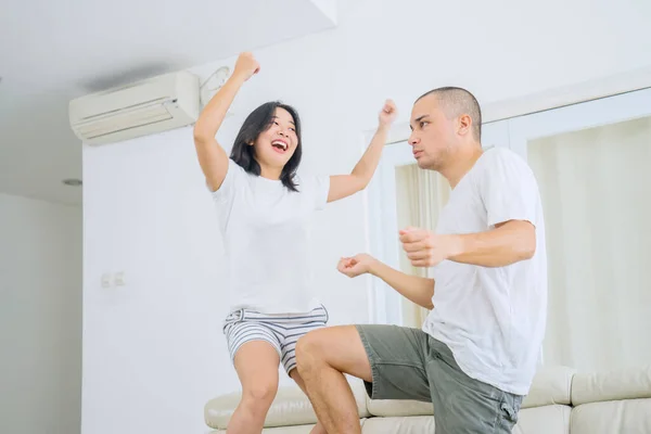 Happy Young Couple Doing Silly Dance Couch While Having Fun — Fotografia de Stock