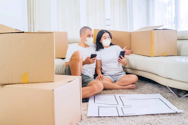 Young Couple Using Mobile Phone Decorating New House Design While — Φωτογραφία Αρχείου