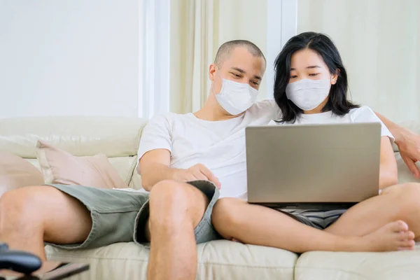 Young Couple Using Laptop Computer Together Couch While Wearing Face — Stockfoto